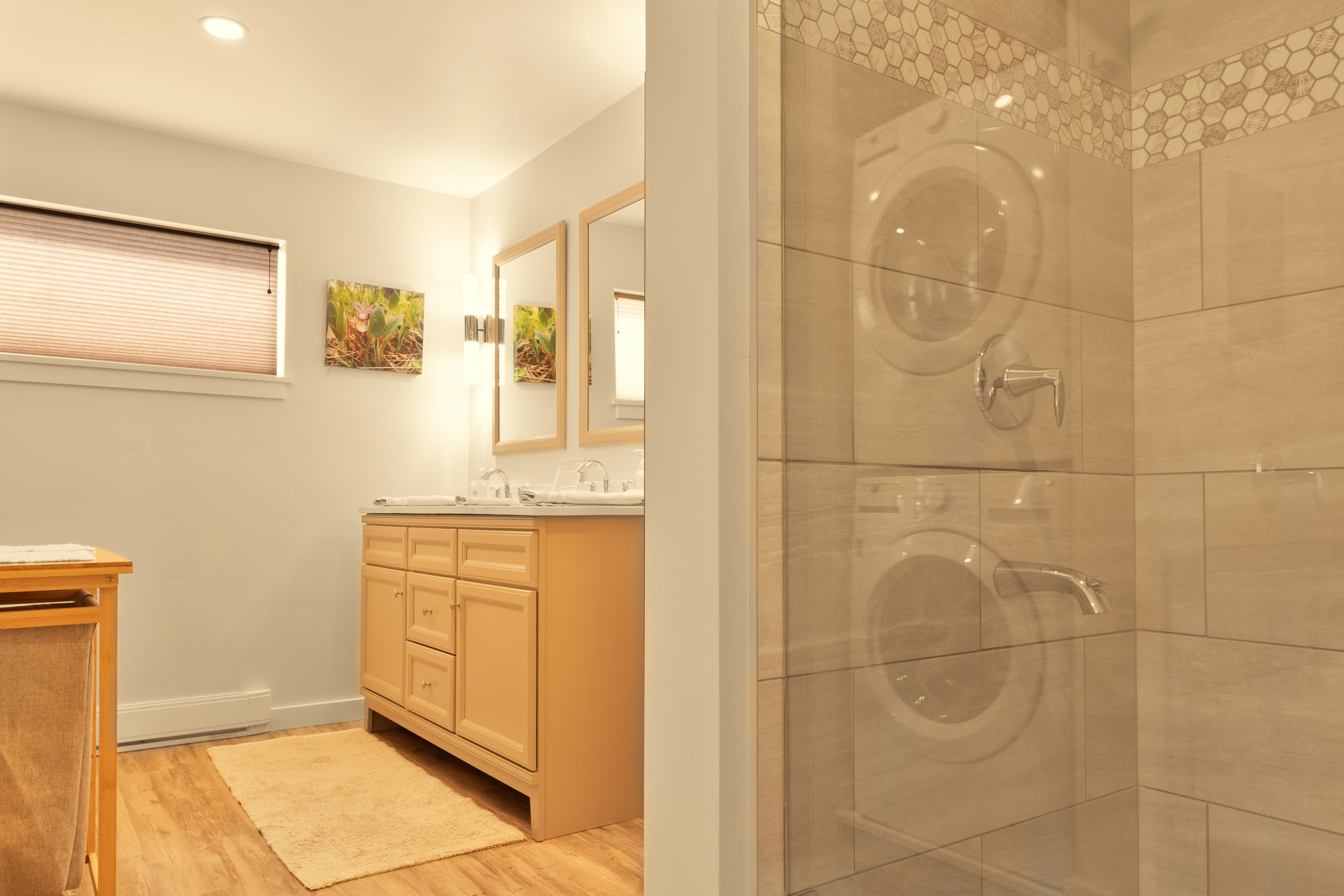 Downstairs bathroom with separate shower and tub, washer/dryer, and double vanity